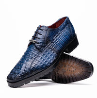 Close-up of Ragusa navy blue caiman crocodile leather derby shoe with hybrid sole on white background.