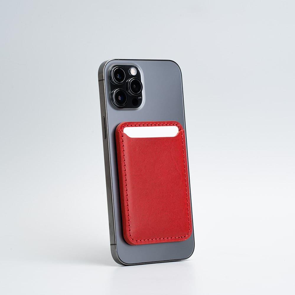 Red top-grain leather iPhone wallet with MagSafe attachment, displayed flat on white background.