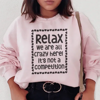 Light pink sweatshirt featuring white 'Relax We Are All Crazy Here' text centered on front.
