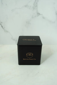 Overhead shot of three reusable tea storage tins arranged on a light-colored background.