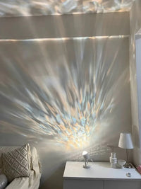 Modern ambient light projector casting blue ripple patterns on wall in low lighting.