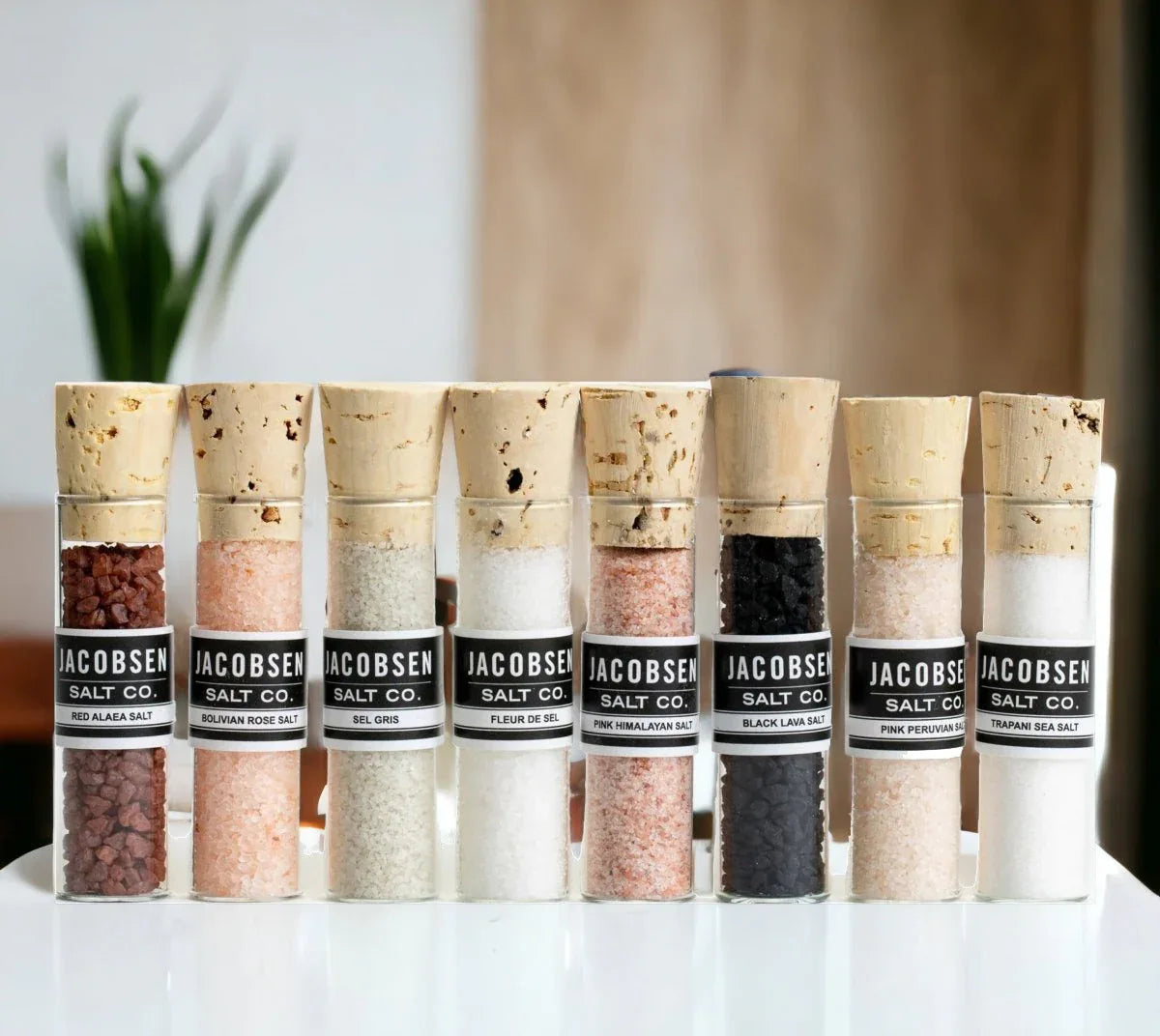 Close-up of assorted salt crystals in small glass vials with labels visible.