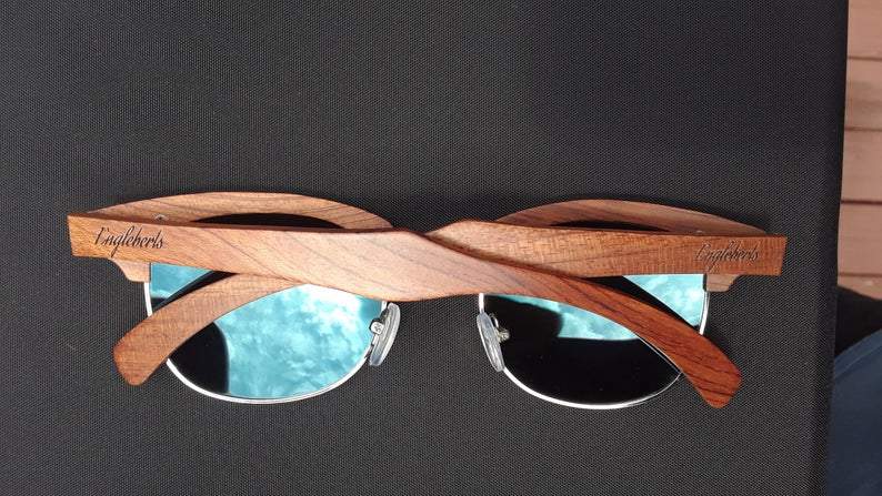 Sandalwood sunglasses folded with visible blue polarized lenses and wooden frame texture.