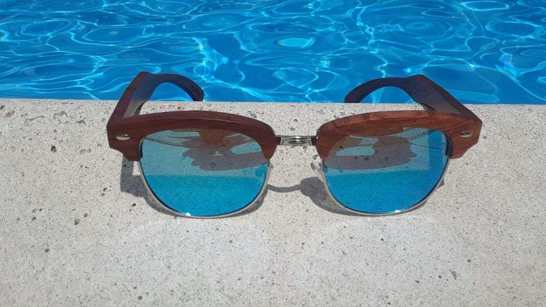 Sandalwood sunglasses resting on white surface with reflection of lenses visible.