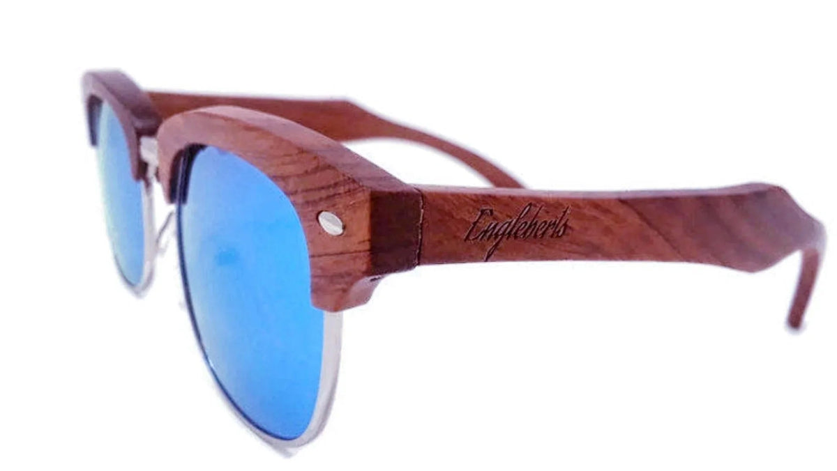 Close-up on artisan engraved wooden temple arm of sunglasses showing intricate craftsmanship.