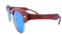 Close-up on artisan engraved wooden temple arm of sunglasses showing intricate craftsmanship.
