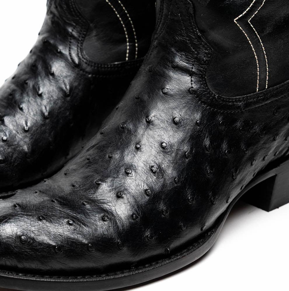 Side angle of Savannah black ostrich skin cowboy boot highlighting red lining inside.
