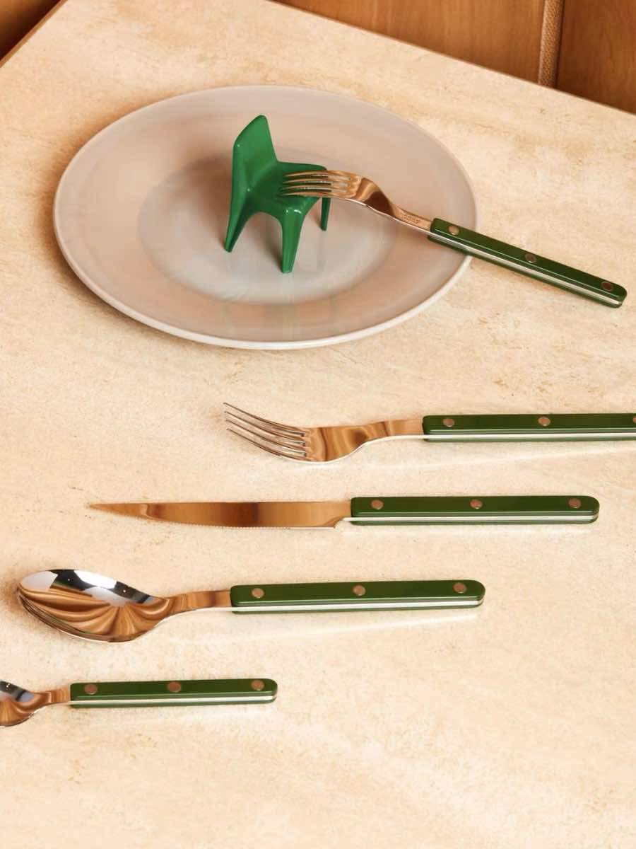 French dopamine cutlery set arranged on a wooden table showcasing polished silverware pieces.