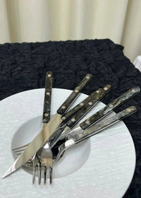 Top view of bistrot style cutlery including forks, knives, and spoons