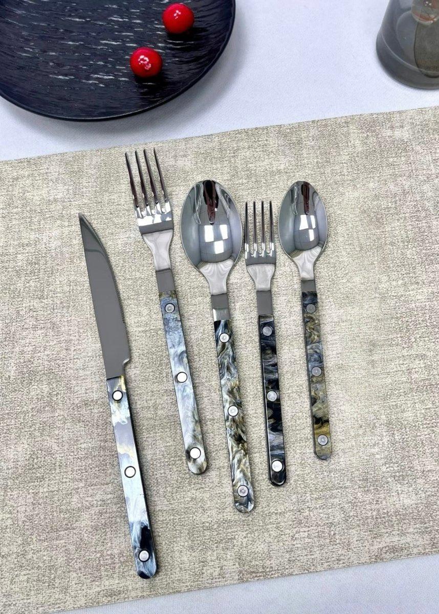 Bistrot style cutlery set on dark wooden tabletop with natural light