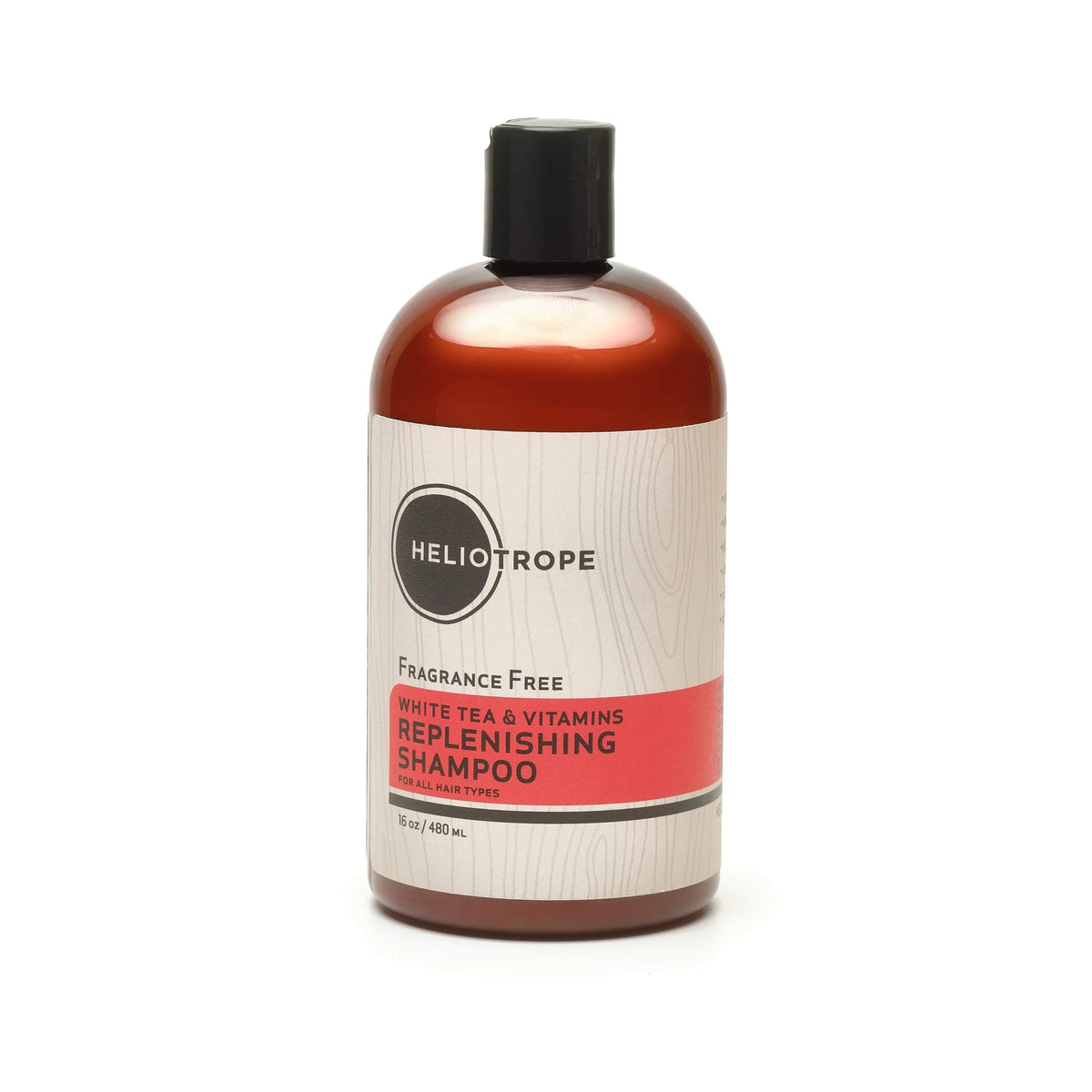 Bottle of White Tea & Vitamins Replenishing Shampoo with natural ingredients displayed nearby