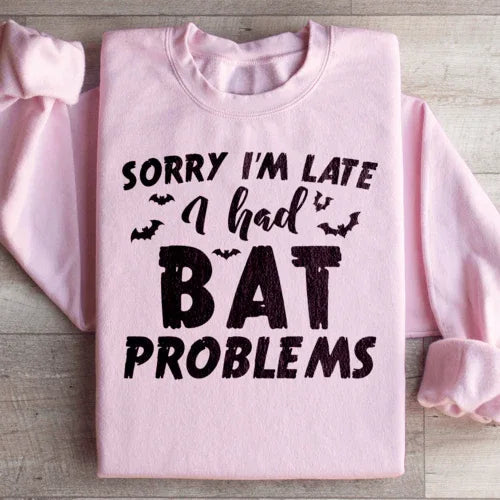 Light pink sweatshirt with Sorry I'm Late I Had Bat Problems text in white on front.