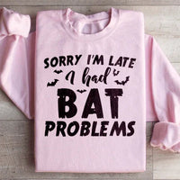 Light pink sweatshirt with Sorry I'm Late I Had Bat Problems text in white on front.