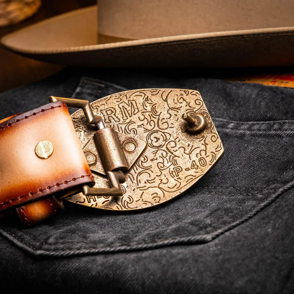 Lifestyle view of person adjusting Texas Belt’s high-quality western buckle on stone brown leather.