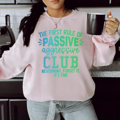 Light pink sweatshirt with 'The First Rule Of Passive' printed in peachy orange font across front