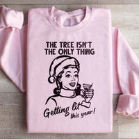 Light pink sweatshirt displaying 'The Tree Isn't The Only One Getting Lit This Year' in stylish text.