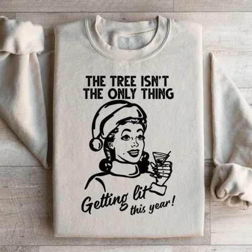 Sand-colored sweatshirt printed with 'The Tree Isn't The Only One Getting Lit This Year'.