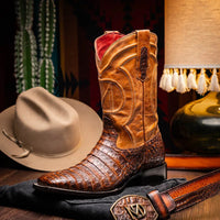 Man wearing Tucson aged maple caiman cowboy boots standing on wooden floor, showcasing boot style.
