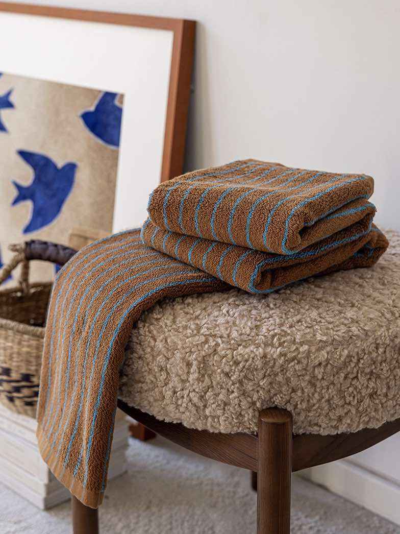 Close-up of organic cotton towel edge with retro stripe pattern and soft, absorbent weave detail.