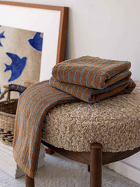 Close-up of organic cotton towel edge with retro stripe pattern and soft, absorbent weave detail.