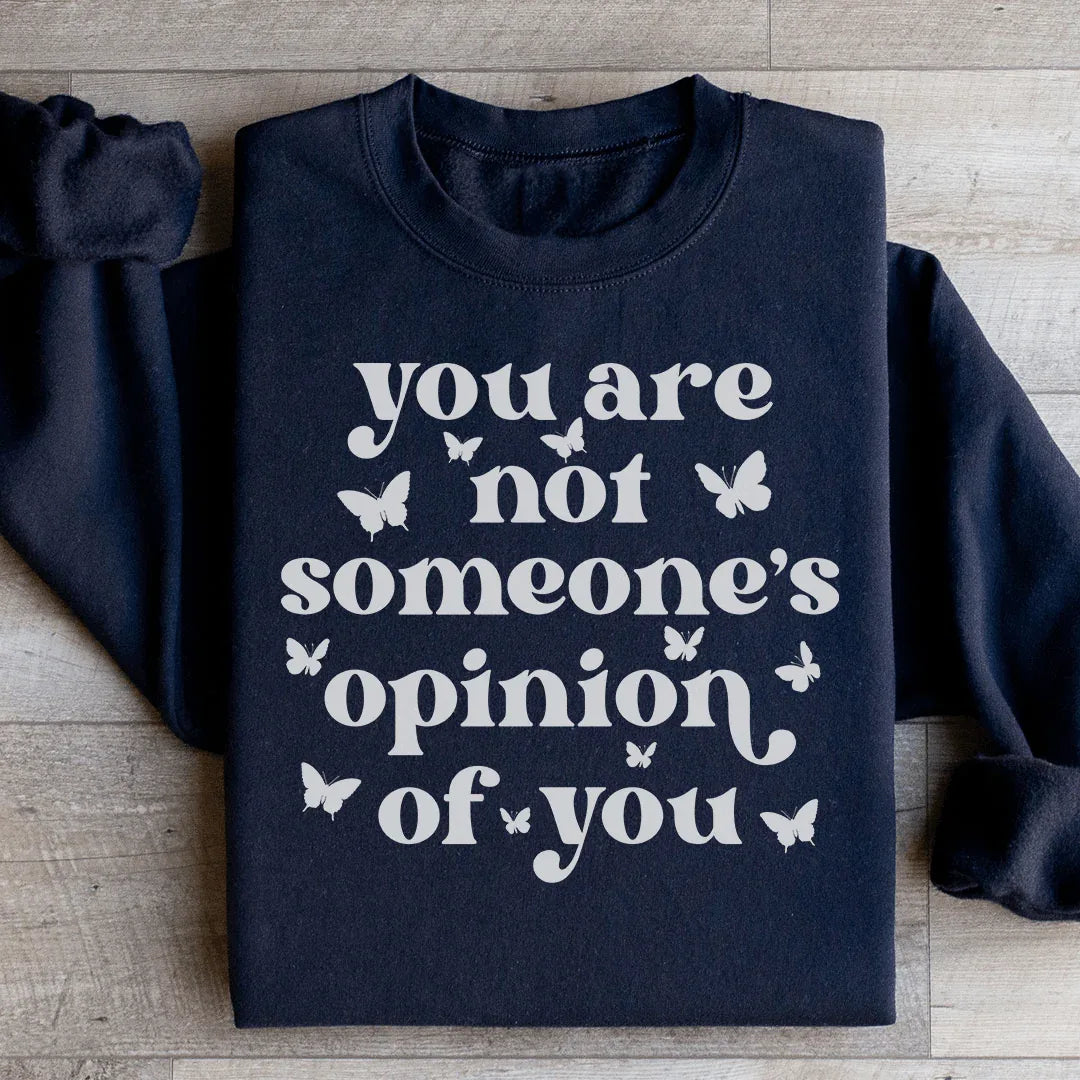 Peach-colored sweatshirt with 'You're Not Someone's Opinion Of You' text design on front.
