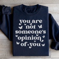 Peach-colored sweatshirt with 'You're Not Someone's Opinion Of You' text design on front.